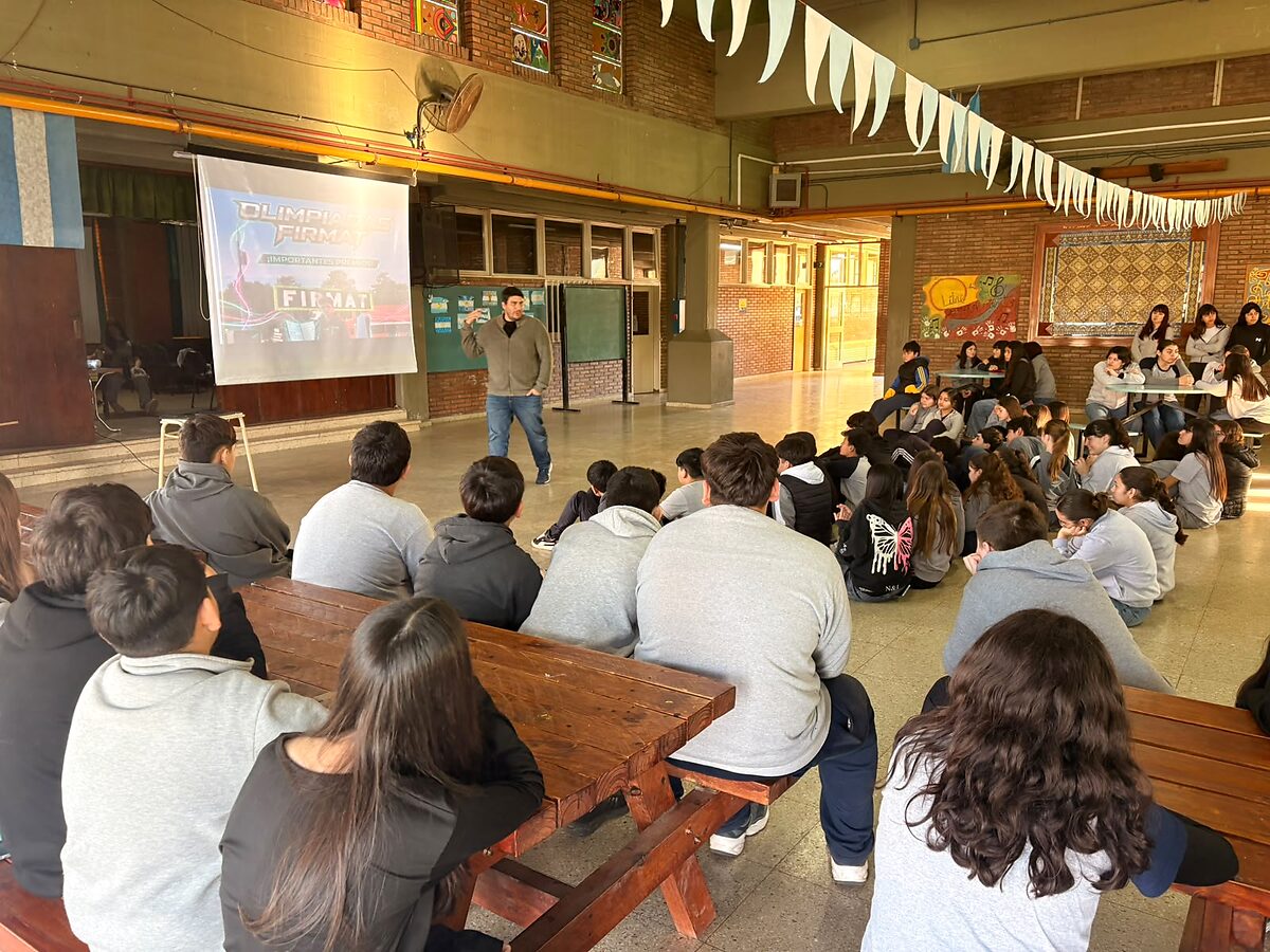 Bernardo presenta la Olimpiada a los alumnos en el patio de una escuela